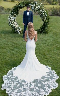 a woman in a wedding dress standing next to a man