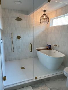 a white bath tub sitting next to a walk in shower