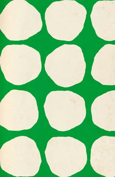 a green background with white circles on the bottom and one circle in the middle that has been cut out