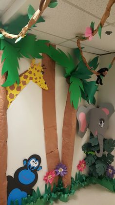 an elephant, giraffe and monkey are hanging from the ceiling in a classroom