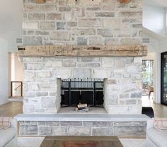 a living room filled with furniture and a fire place under a clock mounted on the wall