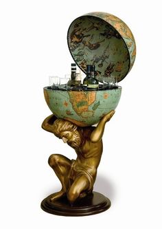 a bronze statue holding a globe on top of it's head