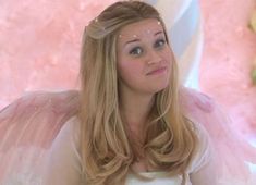 a woman with long blonde hair wearing an angel costume