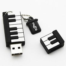 a black and white keychain with music notes on it next to a small keyboard