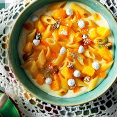 a bowl of macaroni and cheese soup on a lace doily