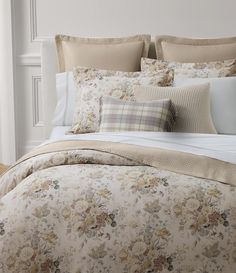 a bed with floral comforter and pillows on it