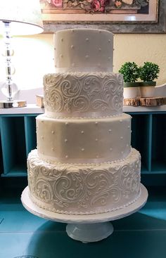 a three tiered white cake sitting on top of a table