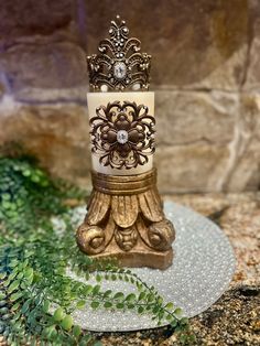 a decorative candle holder sitting on top of a glass plate