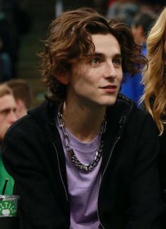 two people sitting next to each other at a basketball game