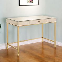 a white desk sitting on top of a hard wood floor next to a potted plant