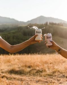 two people are holding jars in their hands and sprinkleing them with water