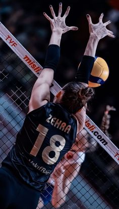 a volleyball player reaching up to hit the ball