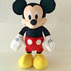 a mickey mouse stuffed animal on a white surface