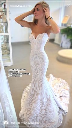 a woman in a white wedding dress standing next to a mirror with her hand on her head