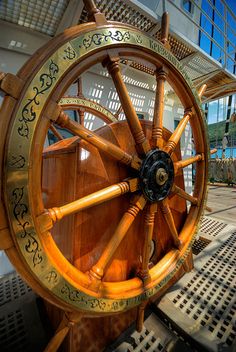 an old wooden steering wheel on display in a museum