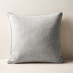 a gray pillow sitting on top of a white table