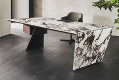 a marbled table with two chairs and a plant in the corner next to it