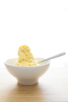 a white bowl filled with ice cream on top of a wooden table