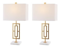 a pair of lamps with white shades on each lamp and one light that is gold