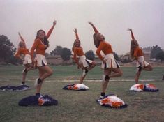 the cheerleaders are doing stunts on their pom - poms in an open field