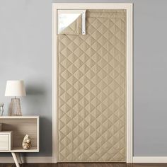 an open door with a beige quilted cover on it and a lamp next to it