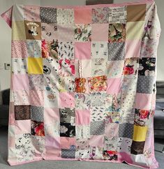 a pink and grey patchwork quilt with lots of small patches on it's sides