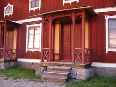 an old red building with two windows and steps leading up to the front door area