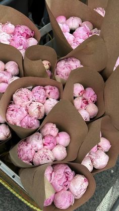 bunches of pink flowers in brown paper wrapped around each other on the back of a truck