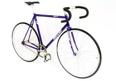 a purple bike with black spokes and seatposts on a white background,