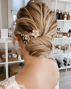 a woman with blonde hair and flowers in her hair is looking at the shelves full of bottles