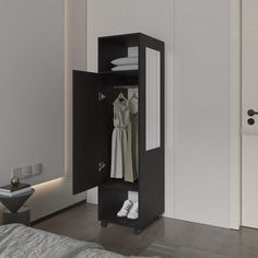 an open wardrobe with clothes hanging on the door and shoes sitting on the floor next to it