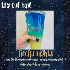 a hand holding a blue and green cup with the words firefly nights written on it