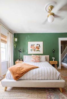 a bedroom with green walls and white bedding