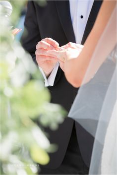 the bride and groom hold hands during their wedding ceremony