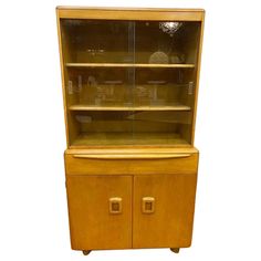 a wooden cabinet with glass doors and drawers