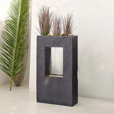 a concrete planter with plants in it on a white floor next to a potted palm tree