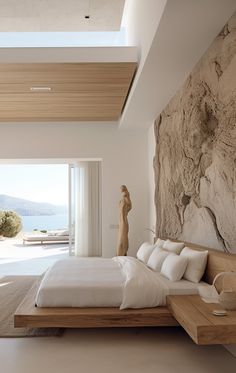 a bedroom with a large stone wall next to a bed in front of a window