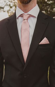 a man wearing a suit and pink tie