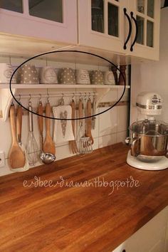 an image of a kitchen with wooden counter tops and utensils hanging on the wall