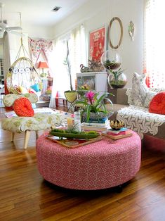 a living room filled with lots of furniture and flowers on top of a coffee table