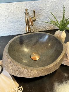 a bathroom sink sitting on top of a counter next to a vase with flowers in it