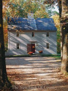 a white house surrounded by trees in the fall