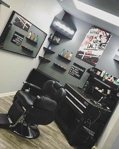 a hair salon with black chairs and pictures on the wall above it, along with other accessories