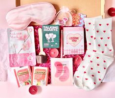 the contents of a valentine's day gift box laid out on a pink surface