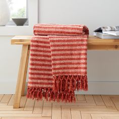 a red and white striped towel sitting on top of a wooden table