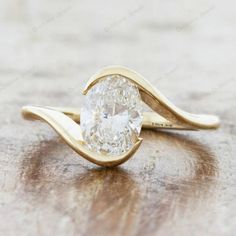 a close up of a ring with a diamond in it on a wooden table top