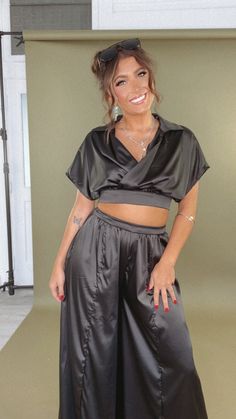 Get ready to turn heads in our Satin Top and Pants Set! This flowy set features a unique wrap effect top and collar neckline. Perfect for adding a little fun to your wardrobe, this top will take you to new heights in style!! Black satin set Top + Pants set Two-piece Wrap effect top Collar neckline Relaxed fit Cropped hem Wide leg Measurements:S: Inseam: 30” | Rise: 13”M: Inseam: 31” | Rise: 14”L: Inseam: 32” | Rise: 15” Model Specs: Emily is wearing a size small in the photo.How will this item f Chic Black V-neck Sets, Chic Two-piece Loungewear Tops, Chic Cropped Two-piece Top Set, Chic V-neck Matching Set, Chic Short Sleeve Top With Matching Set, Chic Short Sleeve Matching Set Tops, V-neck Pant Set For Workwear, Chic Two-piece Set Tops For Party, Chic Party Two-piece Tops Set