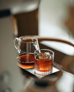 two glasses filled with liquid sitting on top of a table