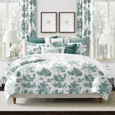 a bed with green and white comforters in a bedroom next to two pictures on the wall