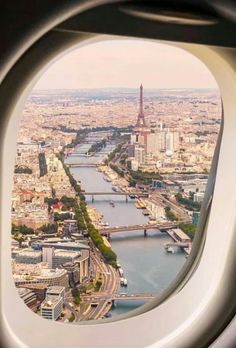 the view from an airplane window looking down at a river and cityscape in paris